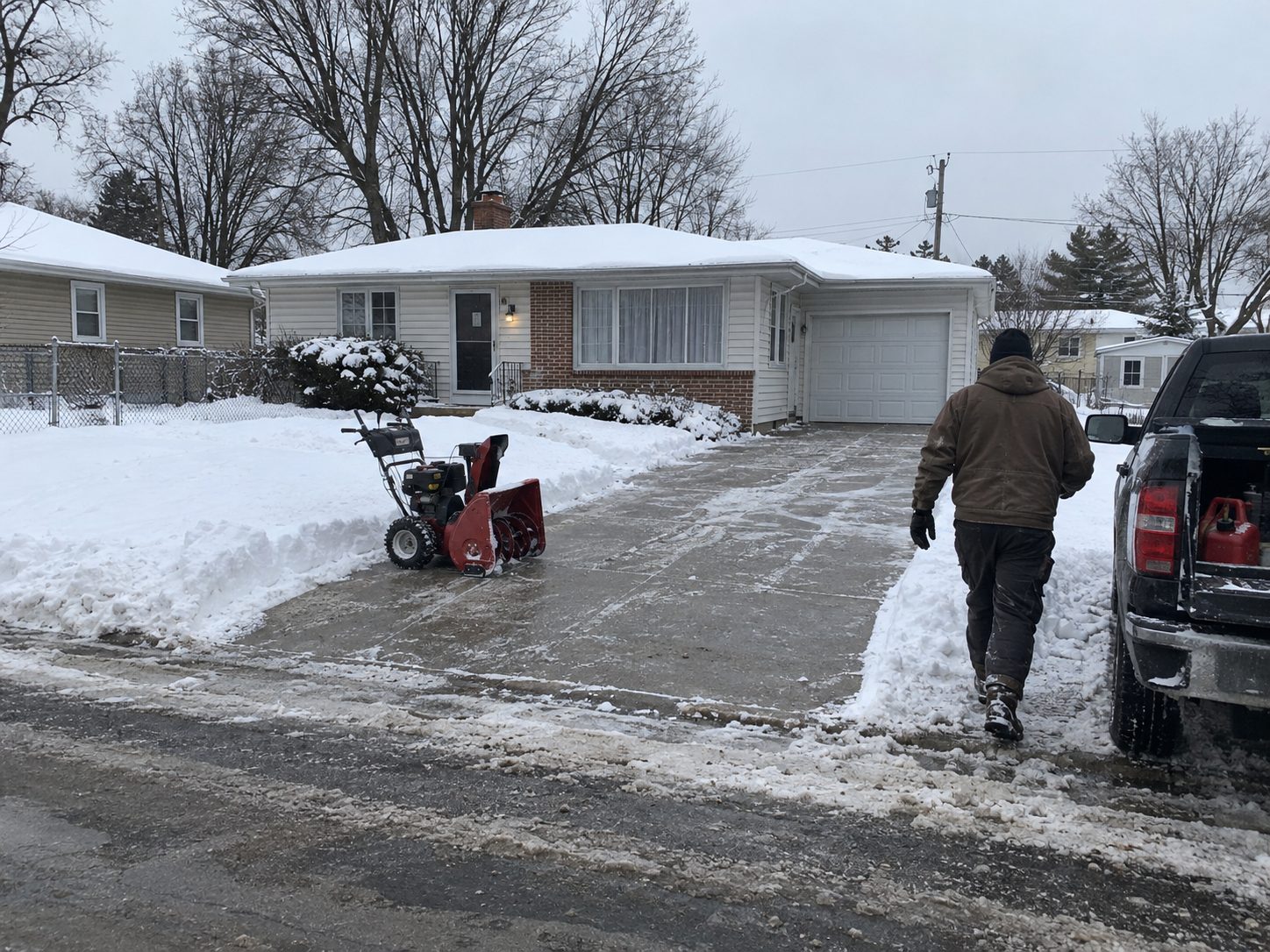 Snow removal crew finishing a cleared residential driveway in Madison, WI